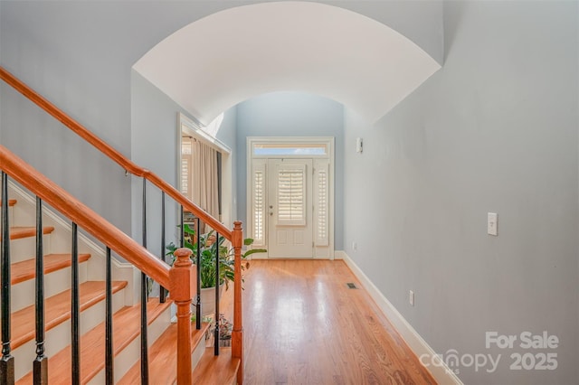 foyer entrance with lofted ceiling and light hardwood / wood-style floors