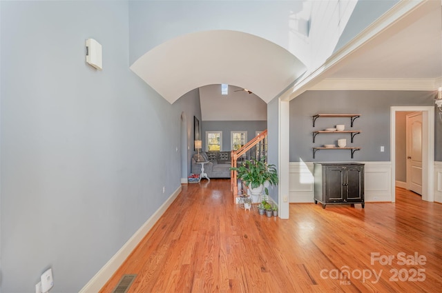 corridor with ornamental molding and light wood-type flooring