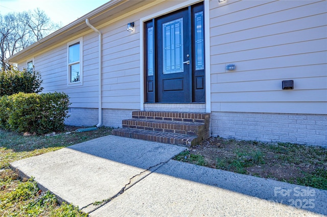 view of exterior entry with a patio