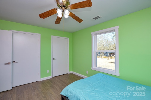 unfurnished bedroom with multiple windows, hardwood / wood-style floors, and ceiling fan