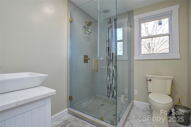 bathroom featuring toilet, a shower with shower door, and sink