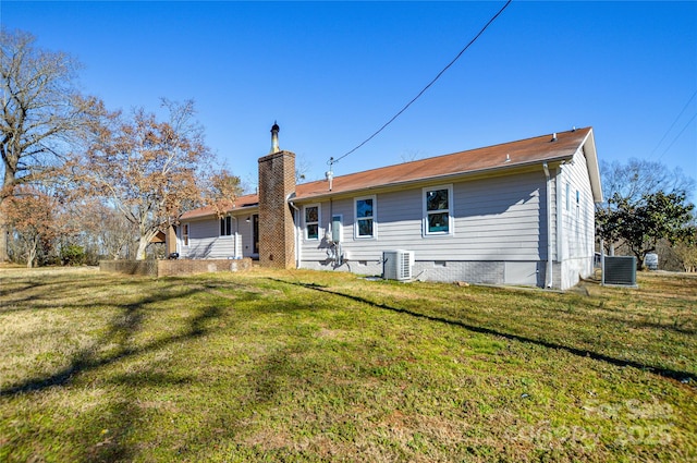 rear view of property featuring cooling unit and a yard