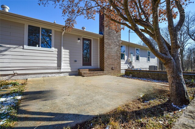 view of front of property featuring cooling unit and a patio area