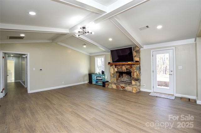 unfurnished living room featuring wood-type flooring, a stone fireplace, vaulted ceiling with beams, and an inviting chandelier