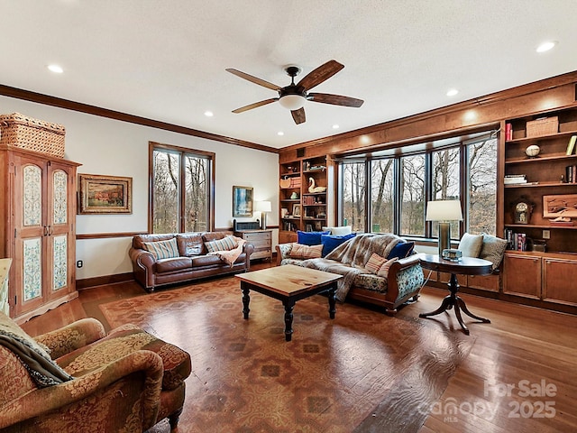 living room featuring dark hardwood / wood-style floors, ornamental molding, ceiling fan, a textured ceiling, and built in shelves