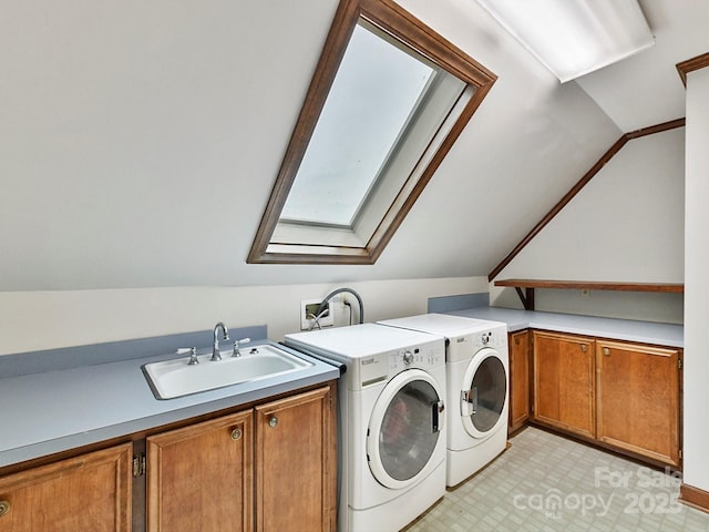 laundry area featuring washer and dryer, sink, a skylight, and cabinets