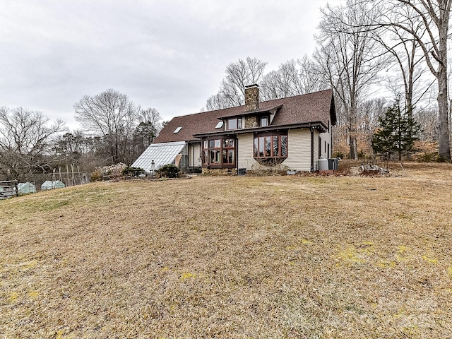 view of front of house featuring a front yard and central air condition unit