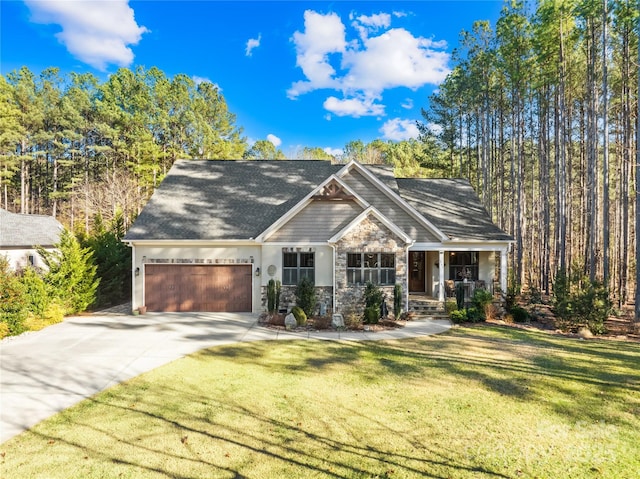 view of front of property with a porch, a garage, and a front lawn