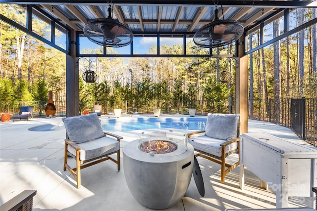 view of patio featuring a fire pit, a fenced in pool, and ceiling fan