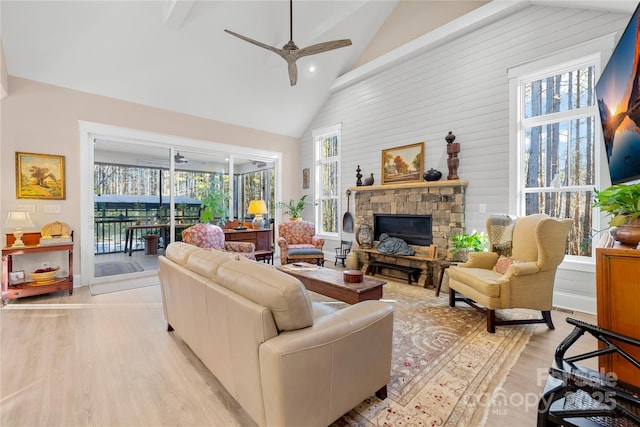 living room with ceiling fan, a healthy amount of sunlight, light hardwood / wood-style floors, and a fireplace