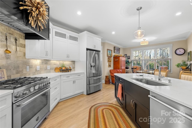 kitchen with hanging light fixtures, appliances with stainless steel finishes, sink, backsplash, and white cabinets