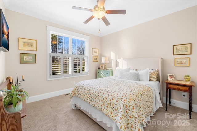 bedroom featuring ceiling fan, ornamental molding, and light carpet