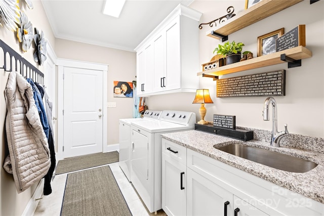 laundry room with crown molding, light tile patterned floors, sink, washer and clothes dryer, and cabinets