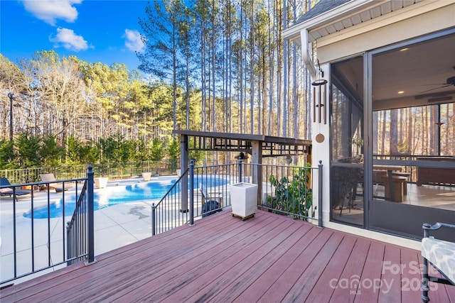 wooden terrace with a fenced in pool, a patio, and a sunroom