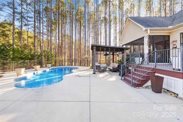 view of swimming pool featuring a patio area and a sunroom