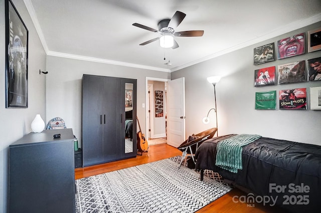 bedroom featuring crown molding, ceiling fan, and light wood-type flooring