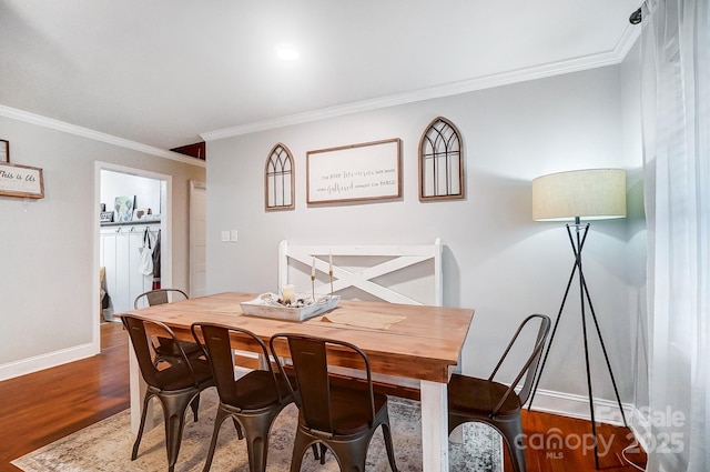 dining area featuring wood-type flooring and ornamental molding