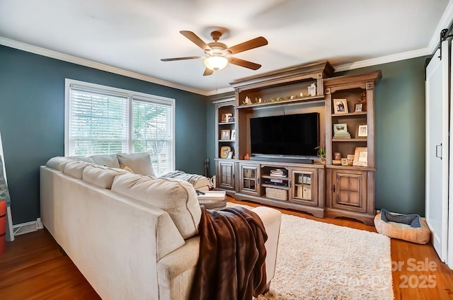 living room featuring dark wood-type flooring, ceiling fan, and crown molding