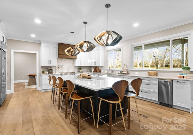 kitchen with white cabinets, decorative light fixtures, and a center island