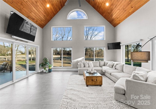 living room with wooden ceiling, plenty of natural light, and high vaulted ceiling