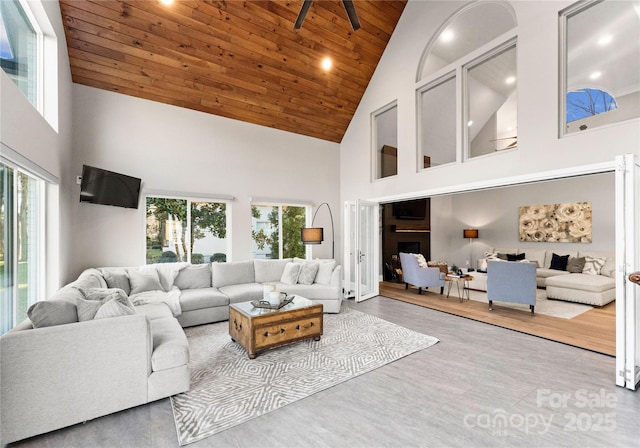 living room with wood ceiling, high vaulted ceiling, and a healthy amount of sunlight