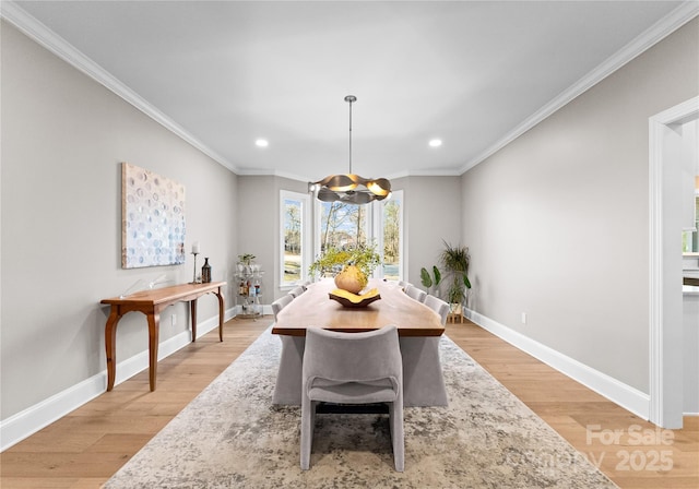 dining space featuring light hardwood / wood-style flooring, a chandelier, and ornamental molding