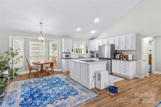 kitchen featuring white cabinetry, stainless steel fridge, and light wood-type flooring