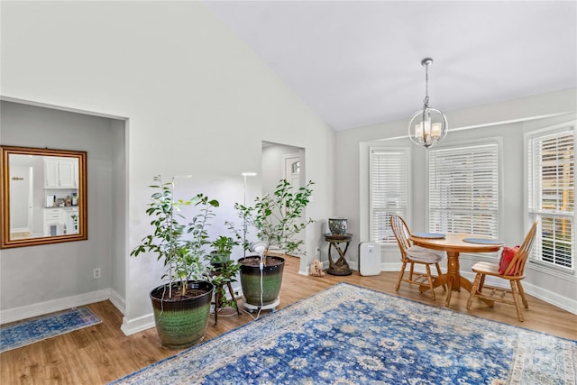 sitting room featuring hardwood / wood-style flooring, high vaulted ceiling, and an inviting chandelier