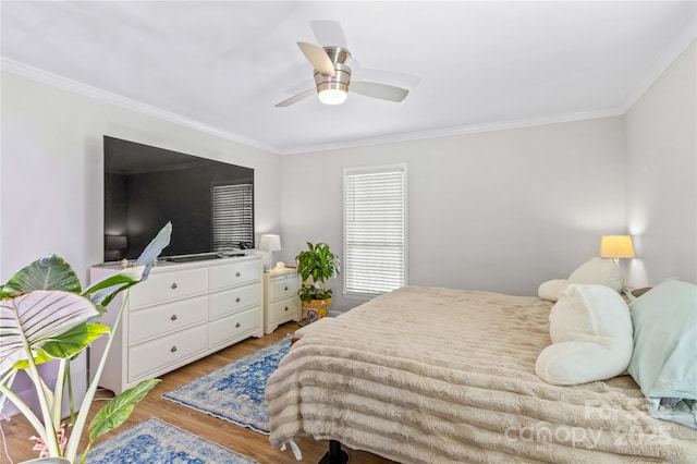 bedroom featuring ornamental molding, ceiling fan, and light wood-type flooring