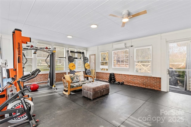 workout area with brick wall, an AC wall unit, and ceiling fan