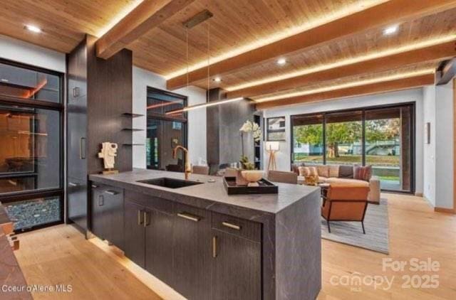 kitchen with light wood-type flooring, dark brown cabinetry, sink, and wooden ceiling