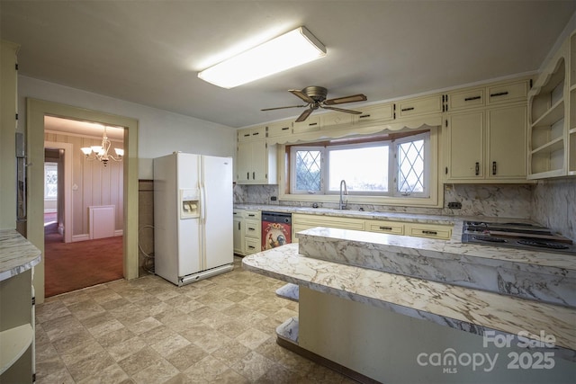 kitchen with appliances with stainless steel finishes, ceiling fan with notable chandelier, tasteful backsplash, sink, and cream cabinets