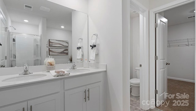 bathroom featuring vanity, toilet, and a shower with door