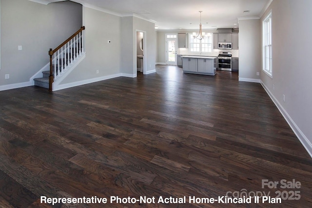 unfurnished living room featuring a notable chandelier, crown molding, and dark hardwood / wood-style floors