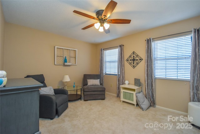 sitting room with ceiling fan and light carpet