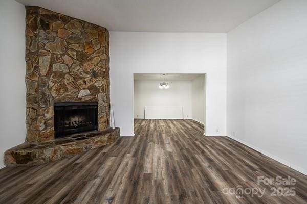 unfurnished living room with a stone fireplace and wood-type flooring