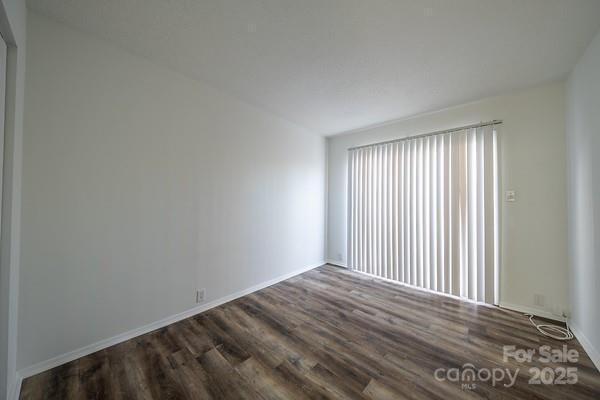 empty room with dark hardwood / wood-style flooring