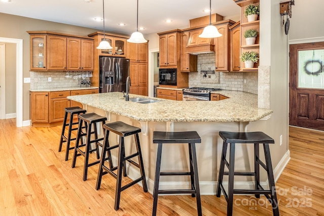 kitchen with a kitchen breakfast bar, pendant lighting, sink, and stainless steel appliances