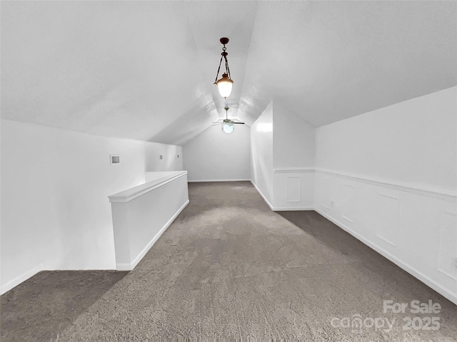 bonus room with dark carpet and lofted ceiling