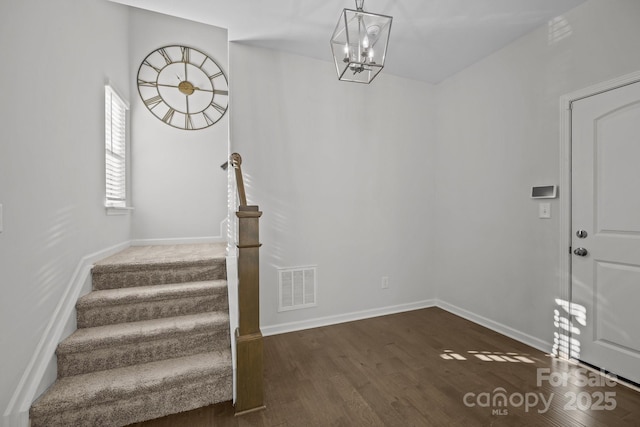 entrance foyer with dark hardwood / wood-style flooring and a chandelier