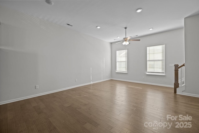 spare room with dark wood-type flooring and ceiling fan