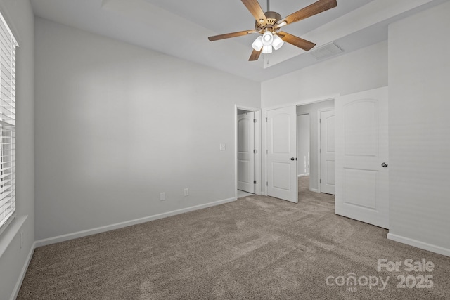 unfurnished bedroom featuring multiple windows, carpet floors, and ceiling fan