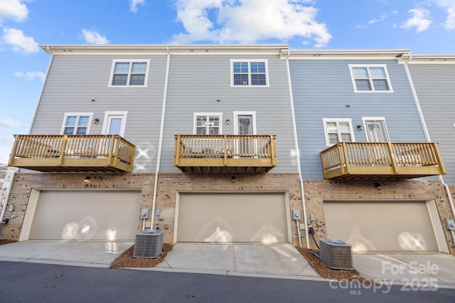 rear view of property featuring a balcony and central AC unit