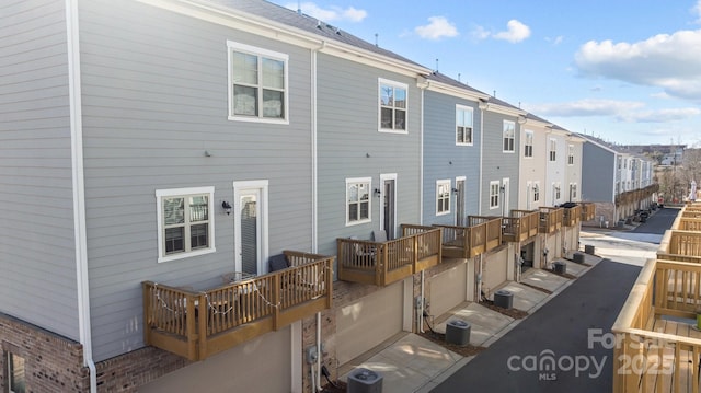 rear view of property with a garage and central air condition unit