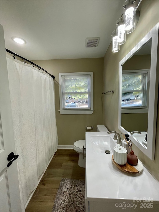 bathroom with hardwood / wood-style flooring, toilet, and vanity