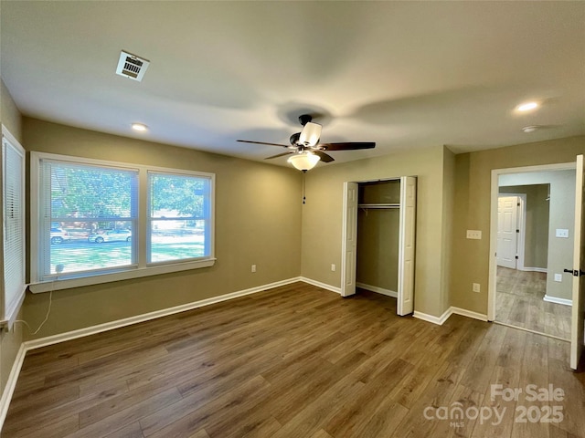 unfurnished bedroom with hardwood / wood-style flooring, a closet, and ceiling fan