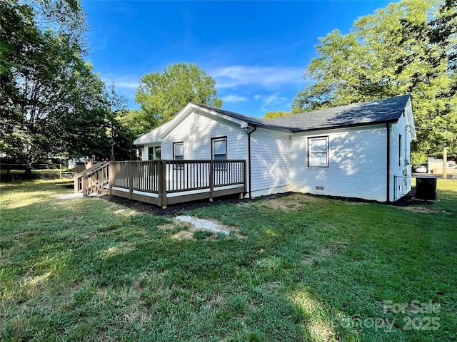 back of house featuring a lawn and a deck