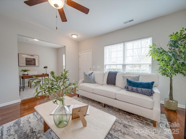 living room with dark hardwood / wood-style floors and ceiling fan