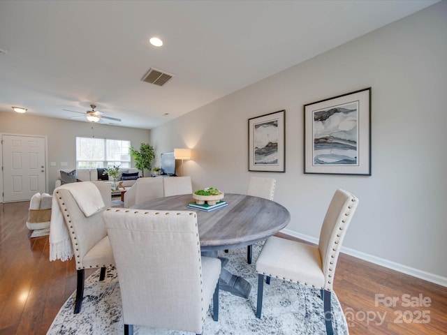 dining room with ceiling fan and dark hardwood / wood-style flooring