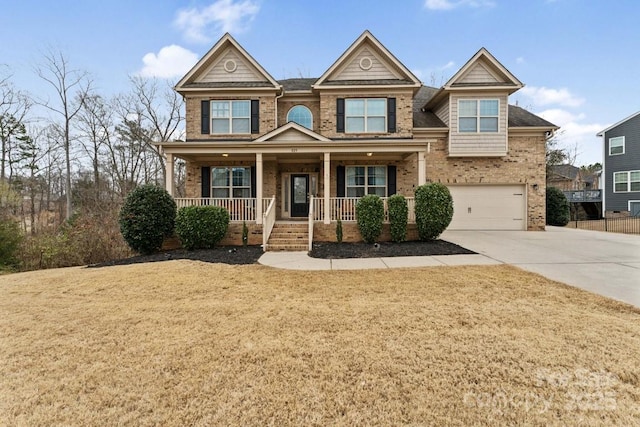 view of front of property featuring an attached garage, concrete driveway, brick siding, and a porch